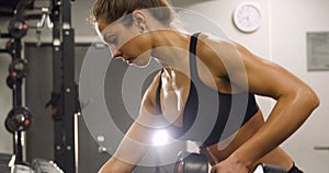 Close-up of dedicated woman training and lifting weights in fitness gym