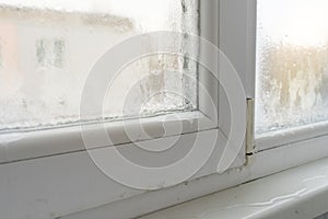 Close up of a defective plastic window with condensation and freezing inside. Poor ventilation  high humidity