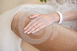 Close-up of a delicate ring on the bride`s hand with pale pink nails.