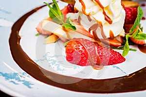 Close up delicious dessert with waffle rolls, ice cream and strawberries