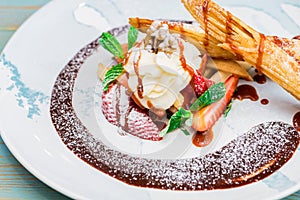 Close up delicious dessert with waffle rolls, ice cream and strawberries