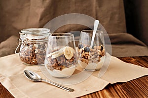 Close up of delicious layered dessert in glass jar, Homemade yogurt with granola and berries, Granola baked with nuts