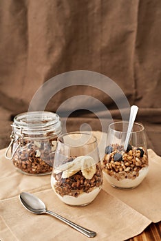 Close up of delicious layered dessert in glass jar, Homemade yogurt with granola and berries, Granola baked with nuts