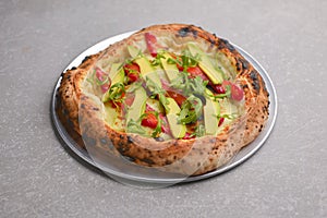 Close-up of a delicious smoked salmon pizza with cheese, avocado and smoked salmon. Sea-food. Textured gray background