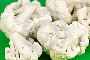Close-up of delicious white cauliflower illustrating a healthy lifestyle isolated on green background