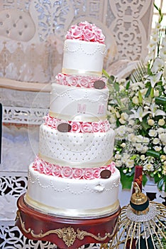 Close-up of delicious white wedding cake decorated with pink roses