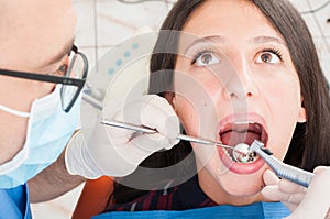 Close-up of dental professional brushing with dentist mirror