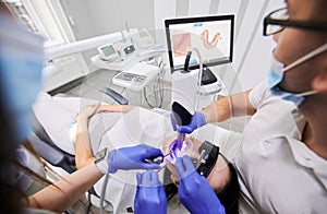 Doctor scanning patient mouth with modern intraoral scanner.