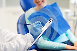 Close up of dentist with clipboard and patient