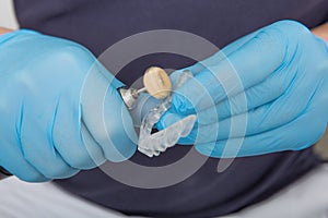 Close up on dentist hands covered with latex gloves shaping mouth guard with file equipment