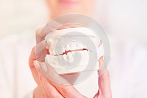 Close-up of dentist holding dentures at clinic