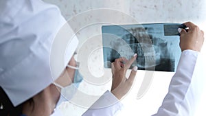 Close up of dentist looking at dental x-ray plate.