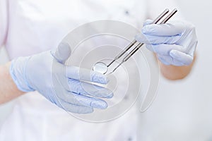 Close up of dentist`s hands holding dental tools
