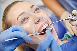 Close up of dentist treating female patient teeth