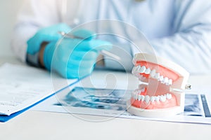 Close up dentures with dentist working on table in clinic