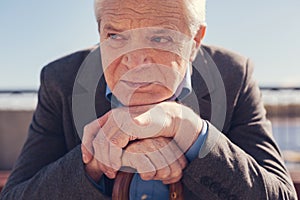 Close up of depressed senior man resting chin on hands
