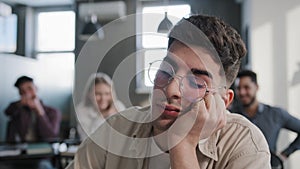 Close-up depressed worried young caucasian guy student sitting at desk alone suffering from bullying mistreatment by