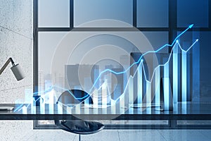 Close up of designer desktop with computer, glowing and growing business chart hologram on blurry blue background. Financial