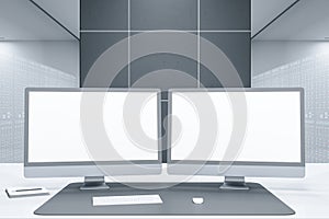 Close up of desktop with clean white computer monitors in futuristic server room office interior. Big data and storage concept.