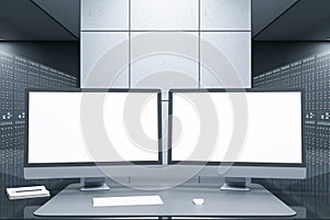 Close up of desktop with empty white computer monitors in futuristic server room office interior. Big data and storage concept.