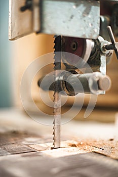 Close-up detail of automatic fixed electric jigsaw in carpentry workshop