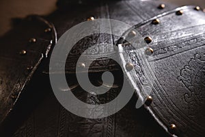 Close up detail Background with armour of the medieval knight. Metal protection of the soldier. Steel Plate. Rivets and engraving