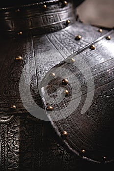 Close up detail Background with armour of the medieval knight. Metal protection of the soldier. Steel Plate. Rivets and engraving