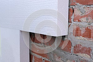 Close-up detail of brick house wall with rigid styrofoam insulation sheet. Modern technology of construction, renovation and