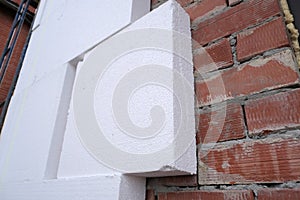 Close-up detail of brick house wall with rigid styrofoam insulation sheet. Modern technology of construction, renovation and