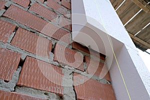 Close-up detail of brick house wall with rigid styrofoam insulation sheet. Modern technology of construction, renovation and