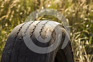 Close-up detail of car wheel tire badly worn and bald because of poor tracking or alignment of the wheels.