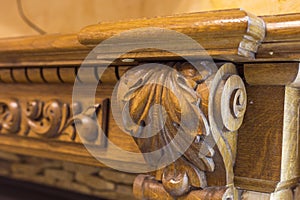 Close-up detail of carved wooden decorative piece of furniture with floral ornament made of natural hardwood. Art craft and design