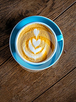 Close-up detail of coffee in a colorful cup on wooden table, vintage style