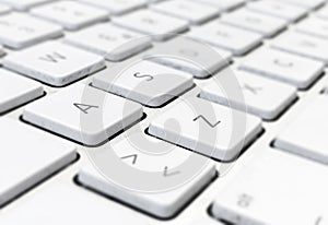 Close-up detail of a computer keyboard with white keys and a gray background