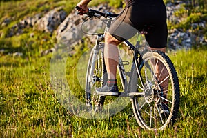 Close-up of detail of cyclist man feet riding mountain bike on rocky trail.