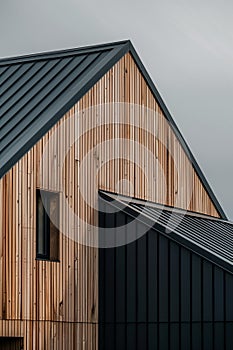 close up detail of dark grey alucobond cladding on the roof, wood slats behind it, contemporary architecture