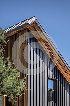 close up detail of dark grey alucobond cladding on the roof, wood slats behind it, contemporary architecture