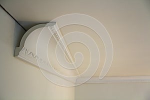 Close-up detail of decoration white molding connected with glue adhesive to wall and ceiling in interior room renovation and