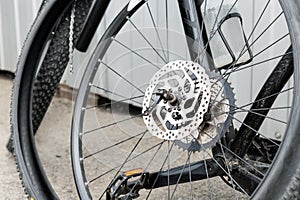 Close-up detail disassembled black carbon fiber bicycle with removed wheel and tyre after puncture or accident at repair