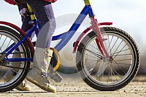 Close-up detail of little girl child feet on a child bicycle