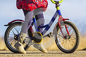 Close-up detail of little girl child feet on a child bicycle