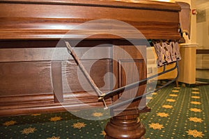 Close - up detail of a luxurious billiard table with a carved wooden leg of precious wood and a pocket for balls