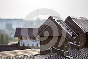 Close-up detail of new built brick plastered chimneys on house top with metal tile roof. Roofing, repair and renovation work