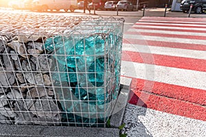 Close-up detail of new modern beautiful gabion fence with metal cage filled by crushed stone and shattered artificial