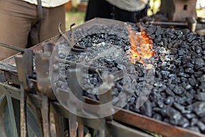 Close-up detail old medieval blacksmith furnace with hot burning coal flame forge iron metal. Craft smith farrier