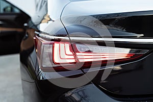 Close up detail on one of the LED red taillight modern luxury car. Car back lights shining. Exterior detail automobile
