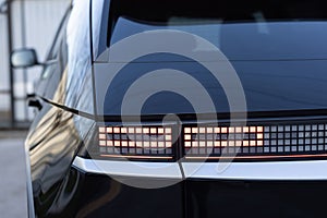 Close up detail on one of the LED red taillight modern luxury car. Car back lights shining. Exterior detail automobile