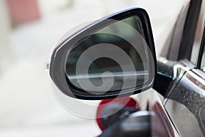 Close-up detail part of dirty back side view car mirror with blurred reflection on white copy space background. Transportation, sa