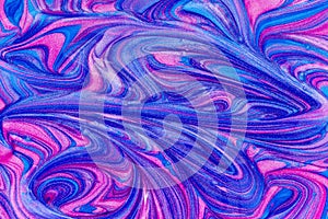 An abstract textured background of pink and blue metallic glitter paint swirls