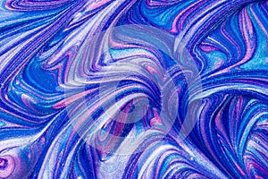 An abstract textured background of pink and blue metallic glitter paint swirls